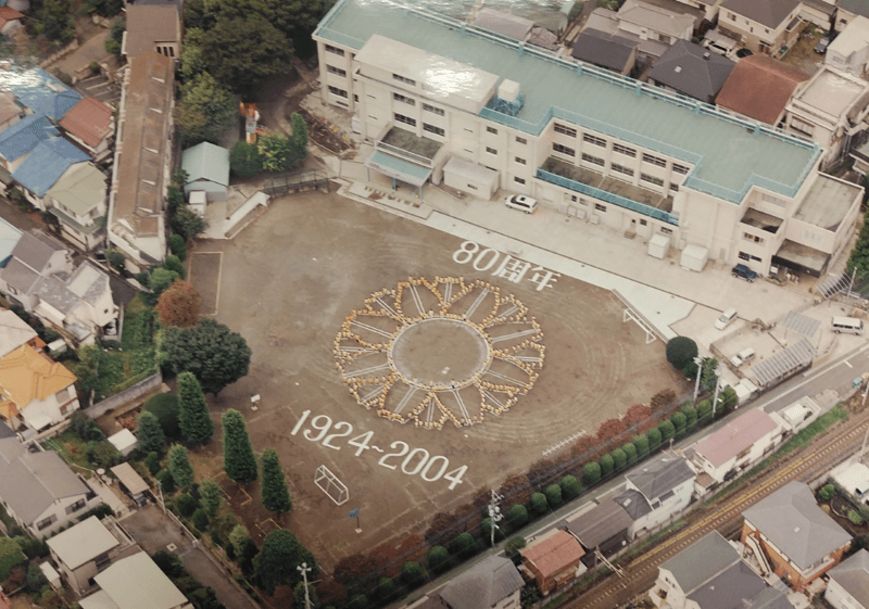 創立80周年を記念する航空写真。校庭に描かれた大きな校章
